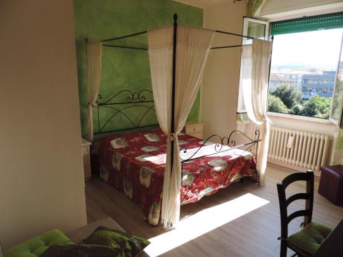 圣温琴佐诺埃米公寓的一间卧室设有天蓬床和窗户。