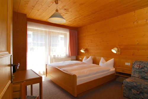 希帕赫Zillertal Apartments的一间卧室设有一张大床和一个窗户。