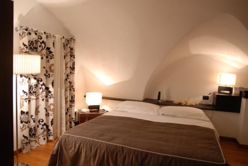 希克利Suite&B的一间卧室配有一张带两盏灯和窗帘的床。