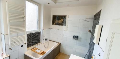 曼海姆sonniges Zimmer mit Balkon im Herzen Mannheims的白色的浴室设有浴缸和水槽。