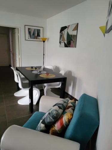里昂Appartement privée Lyon 3的客厅配有桌子和蓝色沙发