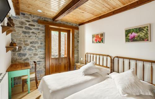 伊萨瓦Casa Rural Francisco Mayo的一间卧室设有两张床和石墙