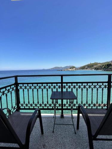 萨摩斯Maria's room的俯瞰大海的阳台配有一张桌子和两把椅子