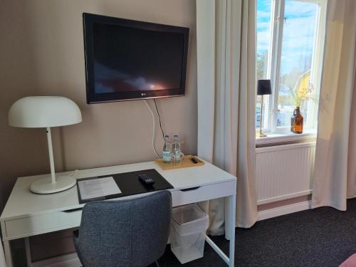 ByskeByske Gästgivargård的一间设有一张桌子的房间,墙上有一台电视机
