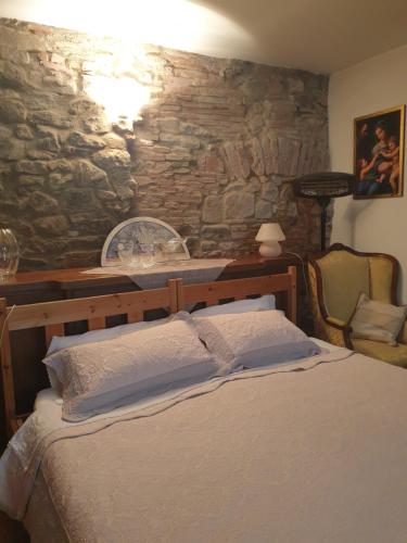 安布拉Helga's House- Una Finestra sul Borgo的一间卧室设有一张床和石墙