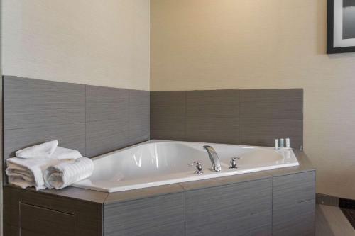 Fox Creek福克斯克里克康福特茵套房酒店的浴室配有浴缸和毛巾。
