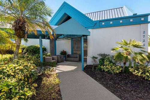 代托纳海滩Baymont by Wyndham Daytona Beach - Intl Speedway的蓝色屋顶和棕榈树的房子
