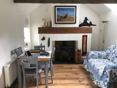 邓多克An Bothán-Cosy Cottage in the Cooley Mountains的客厅配有桌子、沙发和壁炉