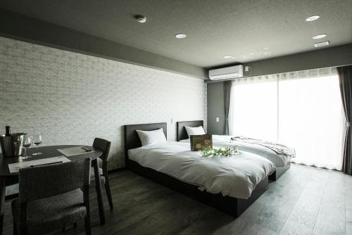 金泽Vacation Rent 金沢的一间卧室配有一张床铺和一张桌子,还有一间用餐室
