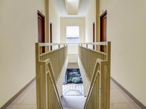 玛琅OYO 91084 Oke Guest House的房屋内带楼梯的走廊