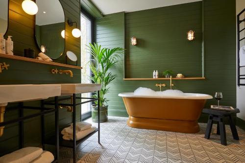 安布尔塞德罗塞庄园酒店的绿色浴室设有浴缸和镜子