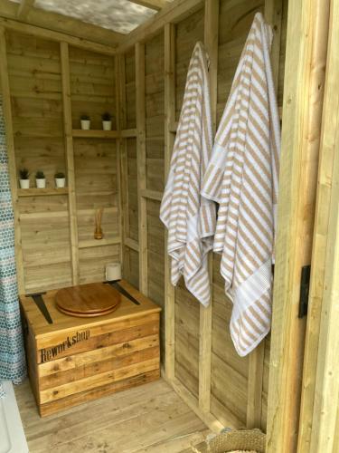 昆布兰Usk Valley Shepherd's Hut的木制桑拿浴室,配有毛巾和木箱