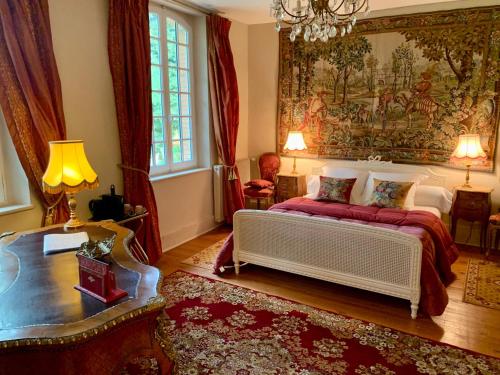 圣利斯Château Ratou的卧室配有一张床,墙上挂着一幅大画
