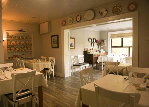 克利夫登本布林之家住宿加早餐旅馆的用餐室配有白色的桌子和白色的椅子