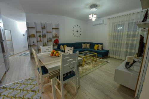 斯库台Denis Comfort Apartment的客厅配有桌子和蓝色沙发