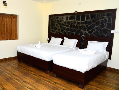 埃尔加德Hotel R Inn Yercaud的配有白色床单的客房内的两张床