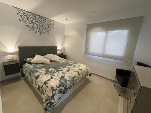 米哈斯科斯塔Chalet del Sol en El Faro的一间卧室设有一张床和一个窗口