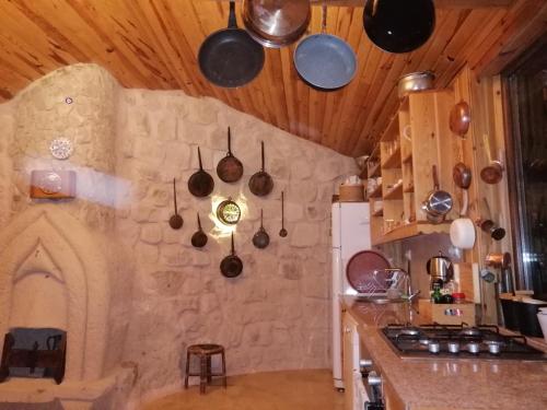 于尔居普patisca cave house in cappadocia的厨房设有挂在天花板上的锅碗瓢盆