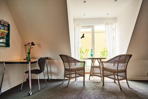 尼克宾法尔斯特Torvets B&B的配有椅子和桌子的房间以及窗户