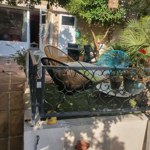 马赛AndandCo的院子内带椅子和植物的铁栅栏
