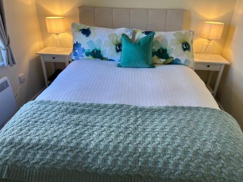 威廉堡Corran, Glenloch View, Fort William 2-Bedroom Loch Side Flat的一张带蓝色和白色枕头的床和两盏灯
