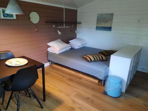 GuldborgGuldborg Camping & Cottages的一张小床,位于一个配有桌子和桌子的房间里,高潮格马克斯韦尔格马克斯韦尔格马克斯韦尔