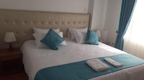 波哥大Hotel en Bogota - Fontana Di Trevi的一张大床,上面有两个枕头