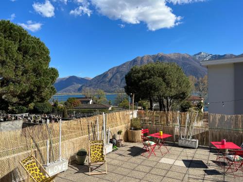 米努西奥Appartamento con terrazza a due minuti dal lago的庭院配有桌椅,背景为山脉