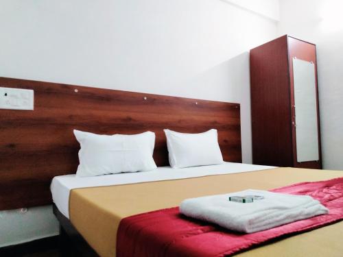 钦奈Royal Green Residency Chennai Airport的一间卧室配有一张大床和木制床头板