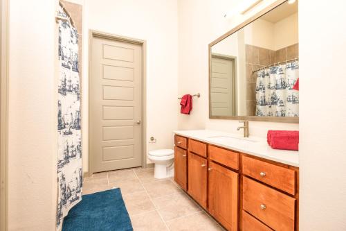 休斯顿RENU at Downtown Houston的一间带卫生间、水槽和镜子的浴室