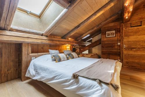 Le TourAppartment Arsene No 6 - Happy Rentals的木墙和天花板的客房内的一张床位