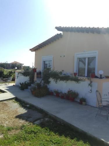 米蒂利尼Studios ΣΤΟΥΣ ΠΥΡΓΟΥΣ ΘΕΡΜΗΣ的白色的房子前面设有庭院