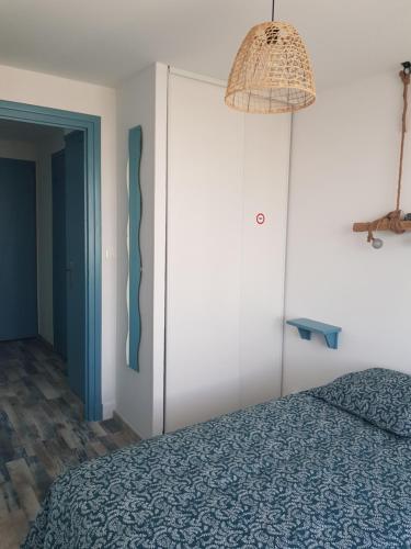 鲁瓦扬Appartement Royan, 200 m de la PLAGE的一间卧室配有蓝色的床和一盏灯