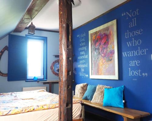 Płóczki GórneThe Old Barn - uroczy, butikowy dom na wsi, rezerwacja minimum 3 noce的一间卧室设有一张床和蓝色的墙壁