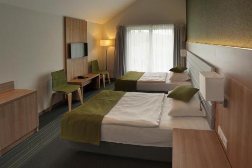 尼苏利采Kalinowe Pola Golf Village的一间酒店客房,设有两张床和电视