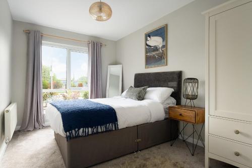 雷丁Stylish Serviced Apartment in Reading的一间卧室设有一张床和一个窗口