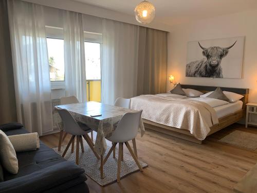 菲拉赫瓦姆巴德公寓酒店的一间卧室配有一张床和一张桌子及椅子