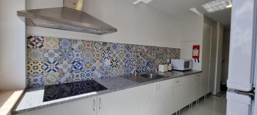 阿威罗Rosa D'Aveiro的厨房设有水槽和瓷砖墙