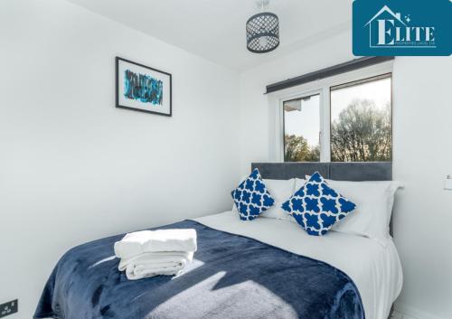 利明顿温泉House with Garden & Private Driveway - Elite Properties的一间卧室配有一张带蓝色和白色枕头的床
