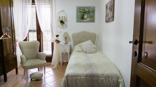 莫迪卡Dolce shabby的一间卧室配有一张床和一把椅子