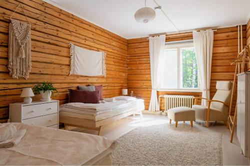 EnonkoskiOlo Center by Kolovesi Nature Park的卧室设有木墙、一张床和椅子