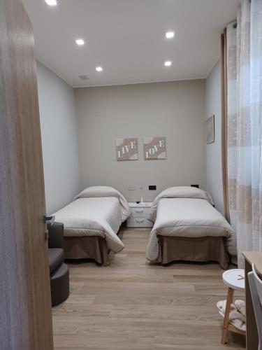 圣韦内里纳Rusina的配有白色墙壁和木地板的客房内的两张床