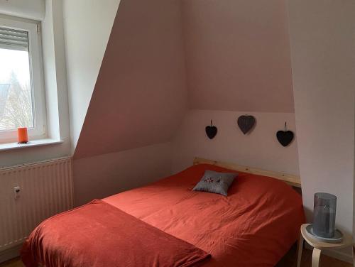 孔特雷克塞维尔Le coeur des VOSGES的一间卧室设有红色的床和窗户。