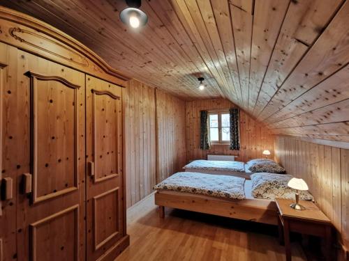格伦德尔湖Ferienhaus Rosl am Grundlsee的一间卧室设有一张床和木制天花板
