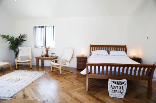 圣梅尔林Mortham的一间卧室配有一张床、两把椅子和一张桌子