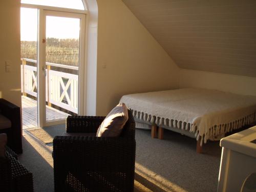 VadumIdyllic country house的卧室配有床、椅子和窗户。
