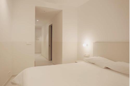 塔拉桑纳阿拉贡HOTEL LA FONDA B&B的白色的卧室配有白色的床和镜子