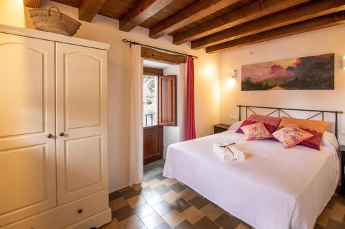 圣胡安包蒂斯塔Casa rural Can Rotes con jardin y barbacoa的卧室配有白色的床和窗户。