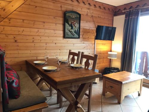 里蒙纽耶Le Chamois des Alpages de Reberty ski au pied的木制用餐室配有木桌和椅子