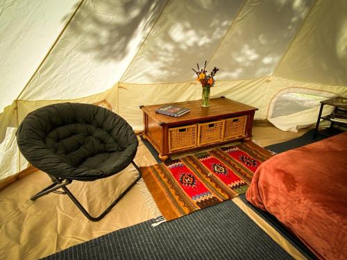 加伯维尔Glamping in the Redwoods的一间卧室配有带椅子和桌子的帐篷